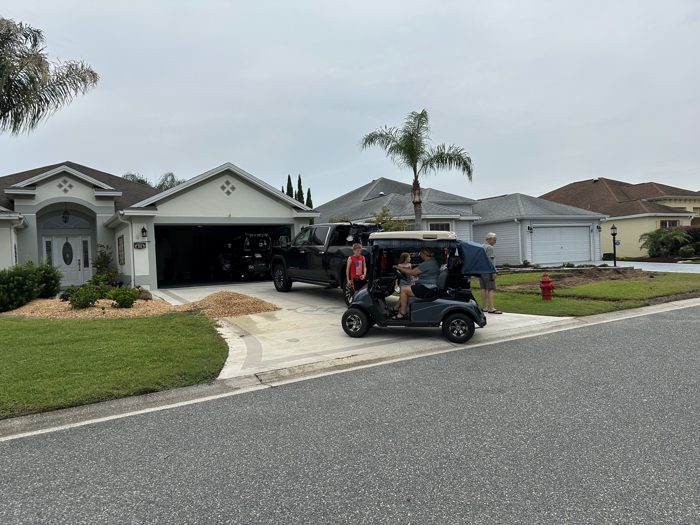 The kids catch a ride in a golf cart while visiting friends in their Florida neighborhood.