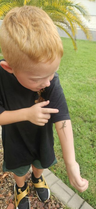 A curious lizard climbs right up one of the kids' arms in the yard.