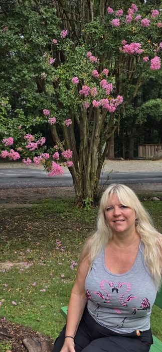Taking a seat on a garden bench beneath a crepe myrtle in full bloom.