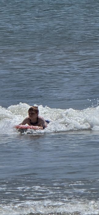 One of the kids catches a wave on the boogie board.