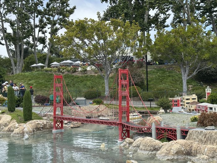 Miniland's LEGO Golden Gate Bridge arches in bright red over the water.
