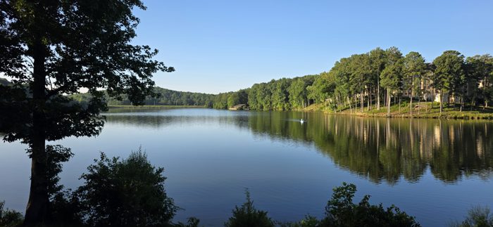 A lone paddler glides across the still lake as the campground wakes up around it.