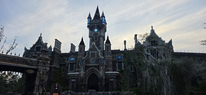 The looming stone clock tower of the castle lit up against the fading dusk light.
