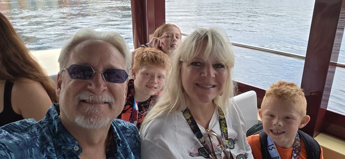 The family crowds in for one more water taxi selfie as the canal slides by.
