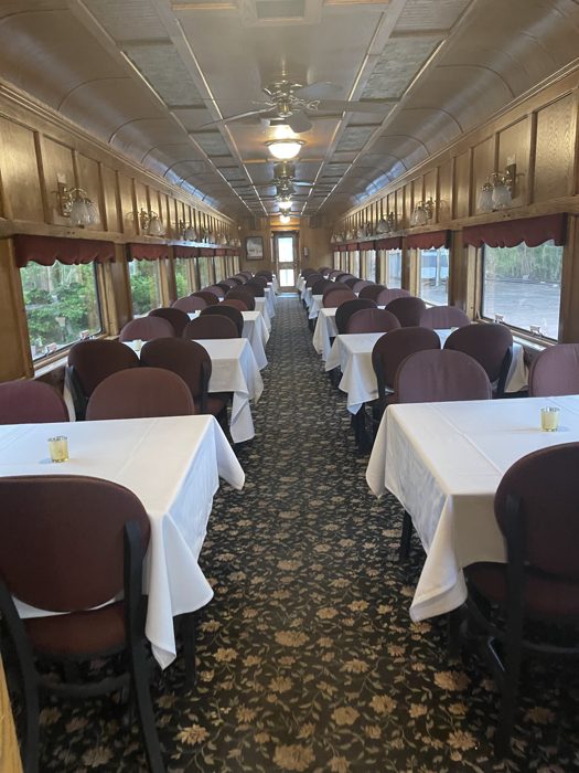 Inside the elegant white-linen dining car of the scenic train.