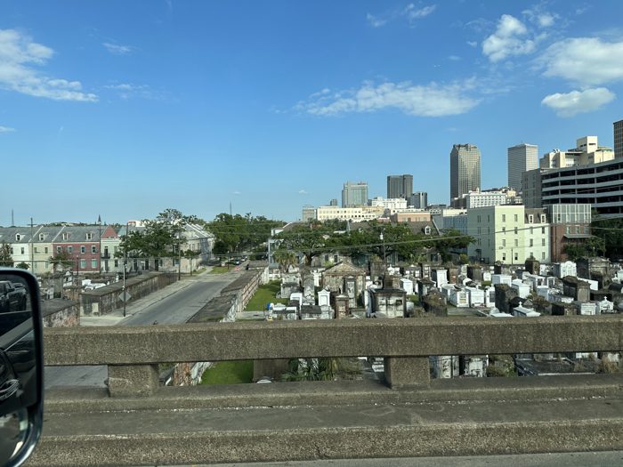 The Caesars Superdome looms above the rows of cemetery tombs.