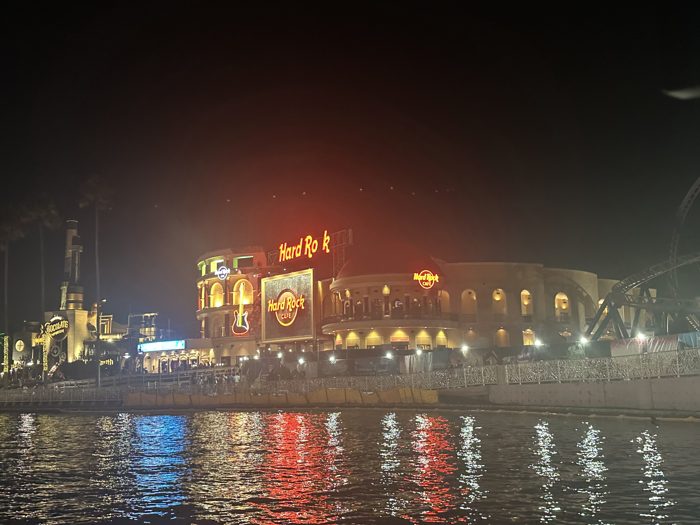 Neon signs shimmer across the lagoon on a warm night out at CityWalk.