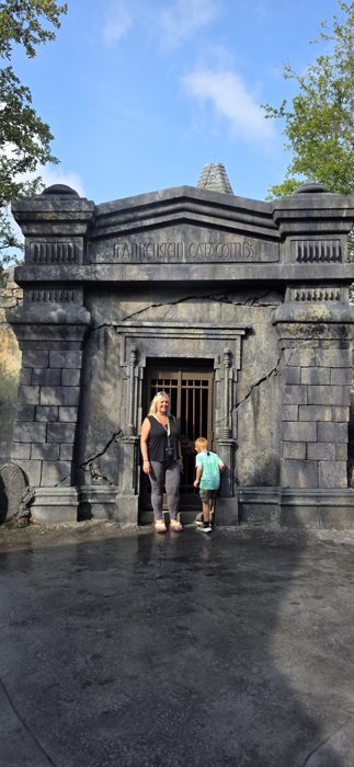 Posing together outside the cracked stone gate of the Frankenstein Catacombs on a bright park morning.