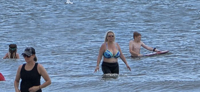 Wading out past the breakers together on a family beach day.