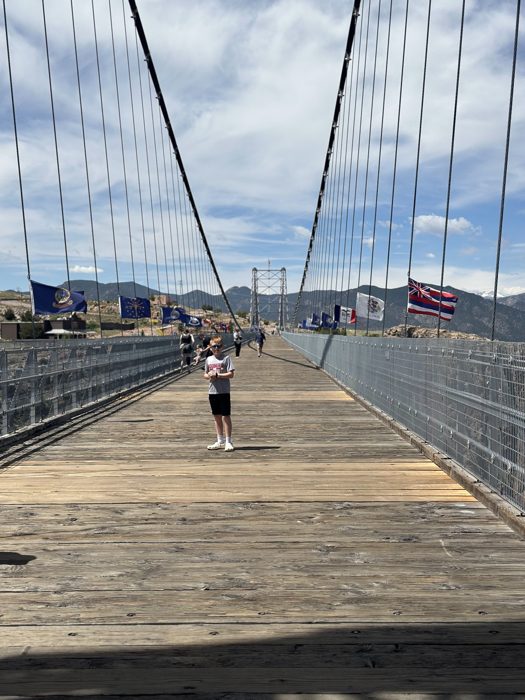Walking the famous wooden-plank deck of the Royal Gorge Bridge, the highest suspension bridge in the country.