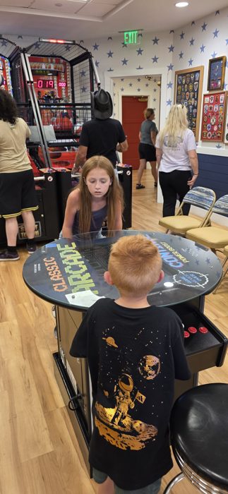 Kids square off over the classic arcade table in the clubhouse game room.
