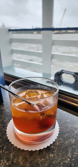 An old fashioned on the rail with the river rolling by.