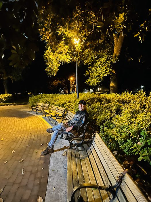 A peaceful moment resting on a bench under the lamplit Savannah square.