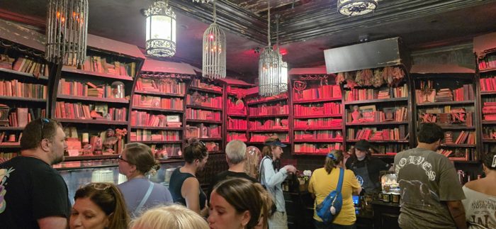 Packed shoulder to shoulder inside Gideon's Bakehouse, the red-lit bookshelves glowing behind the crowd.
