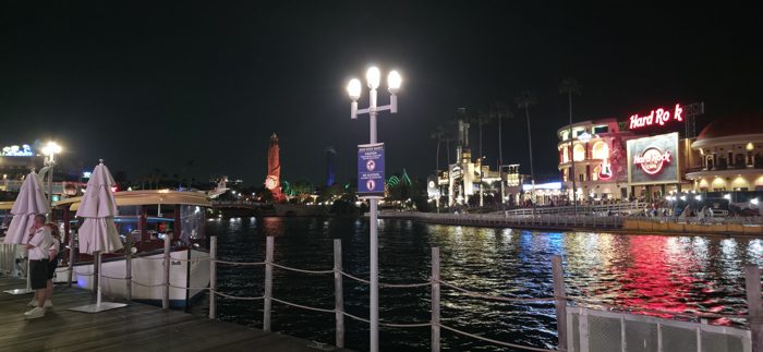 A quiet moment on the dock as the neon of CityWalk shimmers across the lagoon.