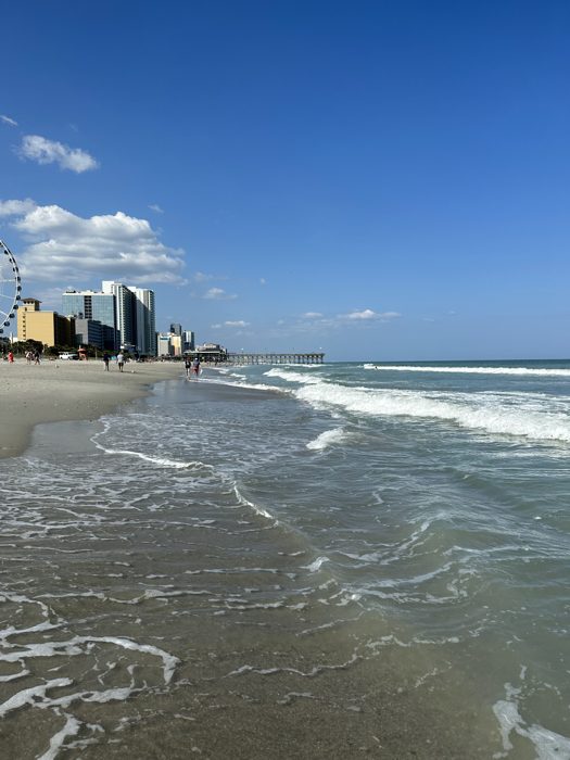 Big blue sky over the breaking waves and the Myrtle Beach skyline.