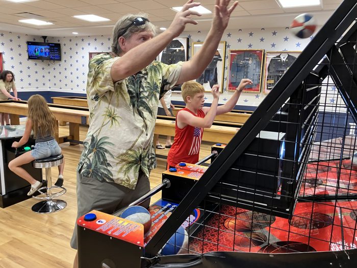 A friend steps in for a round at the basketball arcade game.