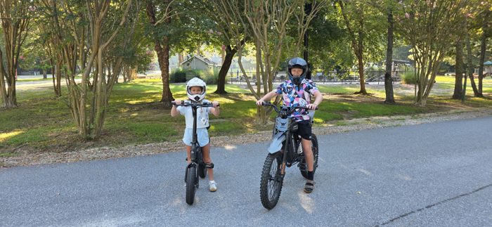 Two of the kids suit up in helmets before an e-bike loop around the campground.