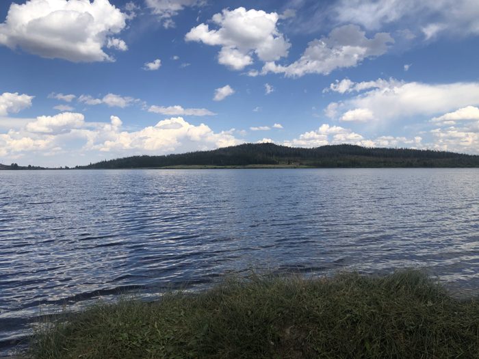 Big Wyoming sky and puffy clouds over the lake near Saratoga, taken from the grassy shoreline.