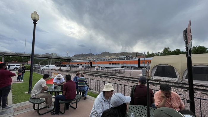 Fellow passengers relaxing at the depot tables under moody Colorado skies before the trip.