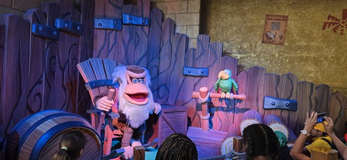 An animatronic old ape and his parrot sidekick put on a show for the crowd in the jungle-themed queue.