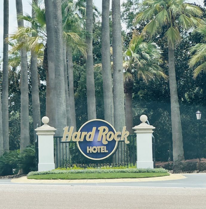 Palm trees frame the entrance sign for the Hard Rock Hotel at Universal Orlando Resort.
