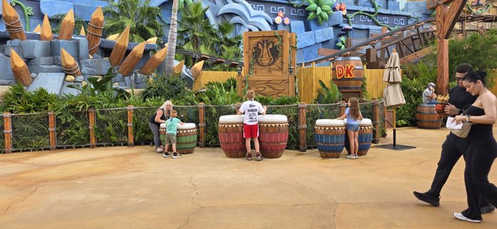 The kids keep the beat going on the big carved drums while other guests stroll past.