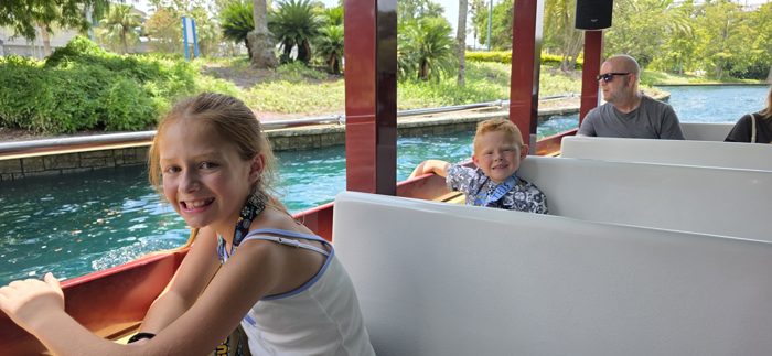 The kids all smiles on the water taxi, dad enjoying the ride just behind them.
