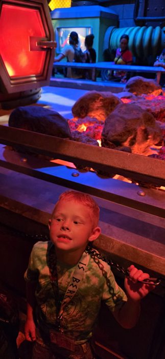 A startled grin from one of the kids as the heat-lamp lava rocks glow behind him.