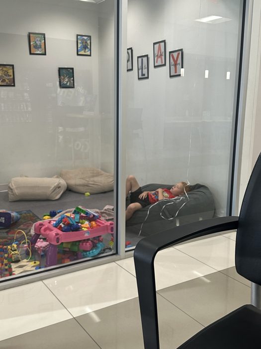 One of the kids crashes out in the dealership's kids play room during the long wait for repairs.