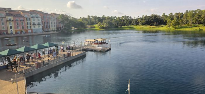 Morning light on the resort's boat launch as the water taxi glides in past the pastel buildings.