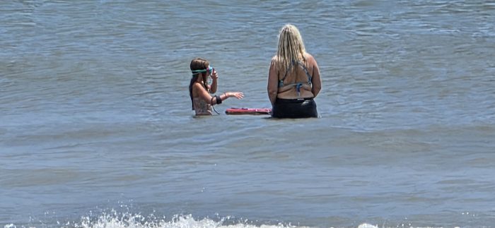 Watching the horizon together, a boogie board bobbing alongside.