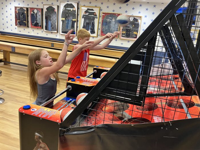 The kids team up for a fast round of arcade basketball.