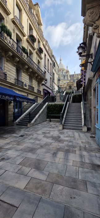 Cobblestone stairs climb toward a miniature Sacre-Coeur in the park's Paris-themed street.