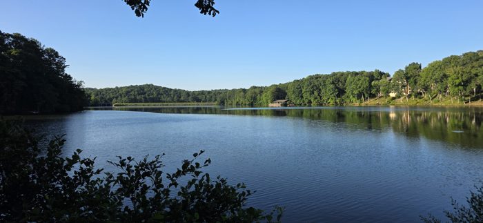 Early morning stillness on the lake outside camp, the water like glass under a clear blue sky.