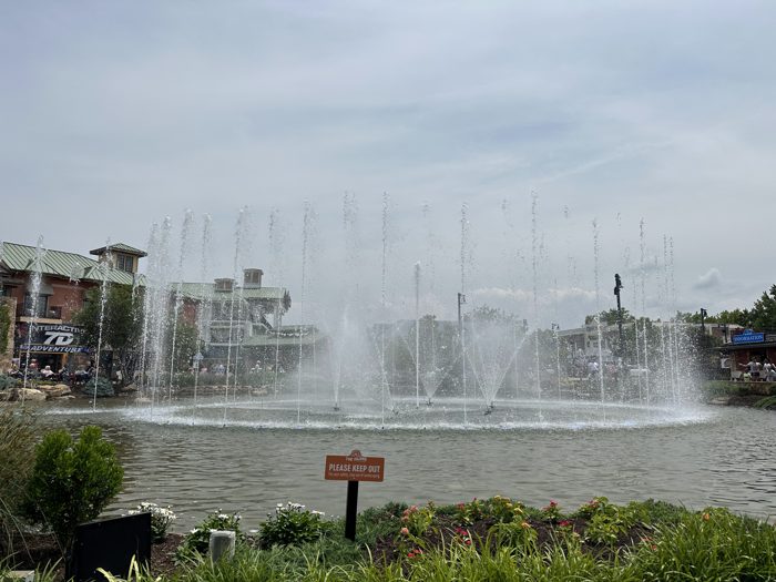 A grand water fountain shooting plumes into the air on a gray afternoon.
