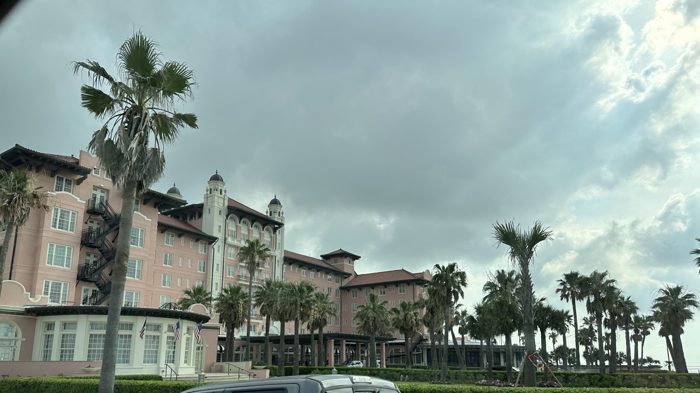 The grand palm-lined resort towering against the moody Gulf-coast clouds.