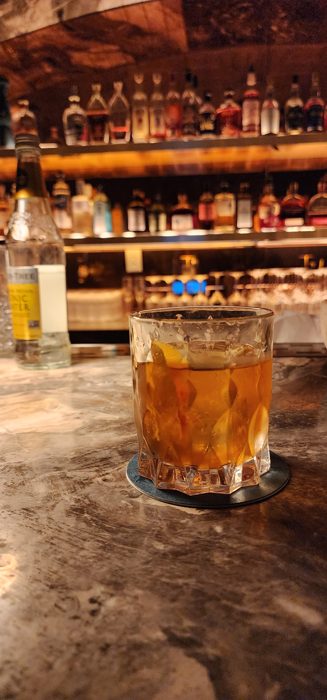 A perfectly poured old fashioned waiting on the bar at Skull's Rainbow Room.