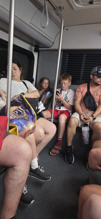 Packed onto the shuttle with the crowd after a long day in the parks, park bag and all.