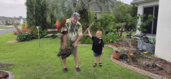 Another shot of the pint-sized helper raising the shovel high next to a proud gardener.