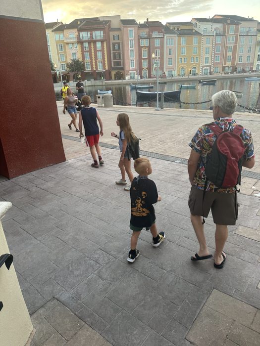 Following the dock past bobbing boats, the family heads back toward the resort as evening settles in.