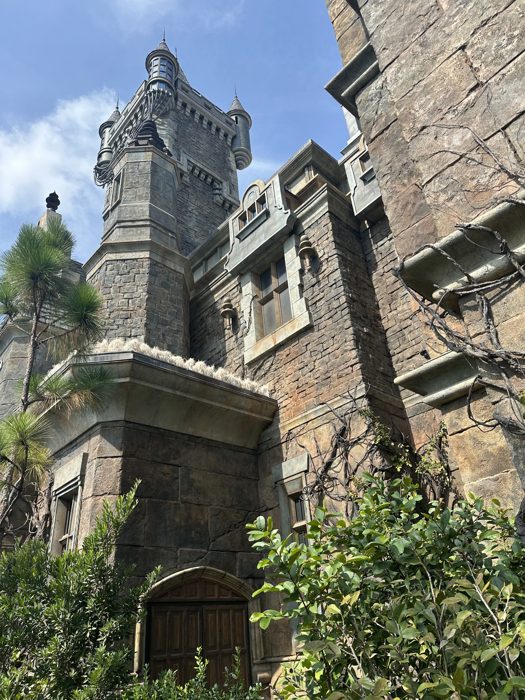 Looking straight up at the towering stone spires of a gothic castle in the new park land.