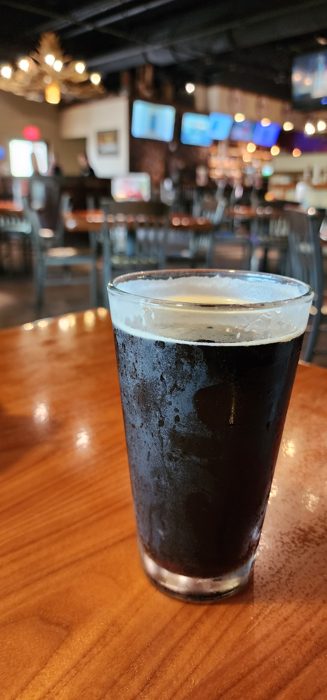 A frosty glass of dark stout poured at the bar.