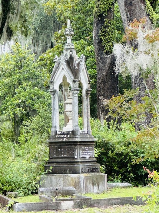 A graceful standing angel monument weathered by time among the headstones.