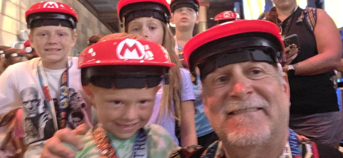 The whole crew crammed in close for a selfie in our red Mario caps.