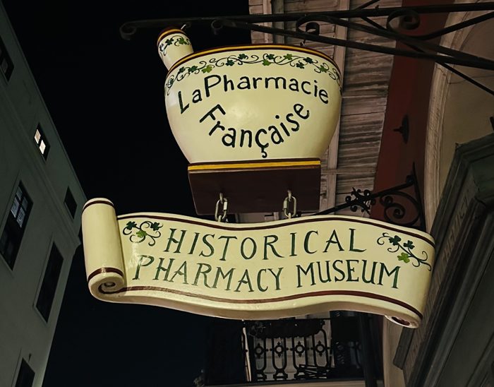 The wrought-iron sign of the New Orleans Historic Pharmacy Museum.