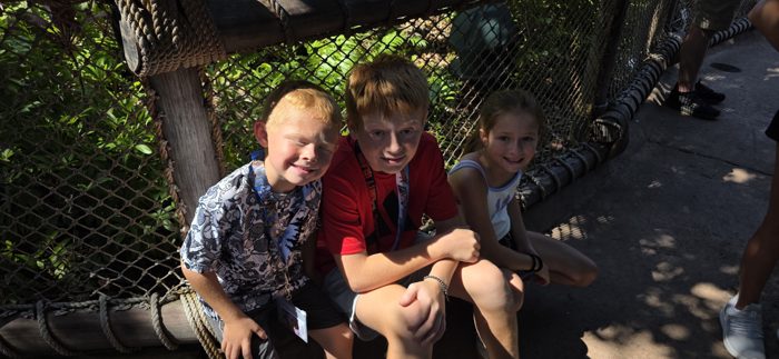 One more shot of the kids squeezed onto the rope bench, still smiling as the line inches forward.