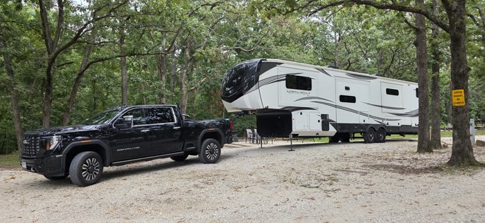 Our rig tucked into a wooded gravel site among the trees for the night.