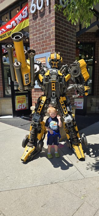 Larger-than-life Transformers robot statues stand guard along a sunny downtown Steamboat sidewalk.