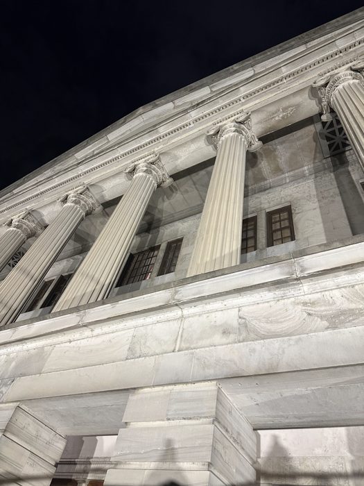 The grand columns of the Tennessee State Capitol glowing against the night sky.